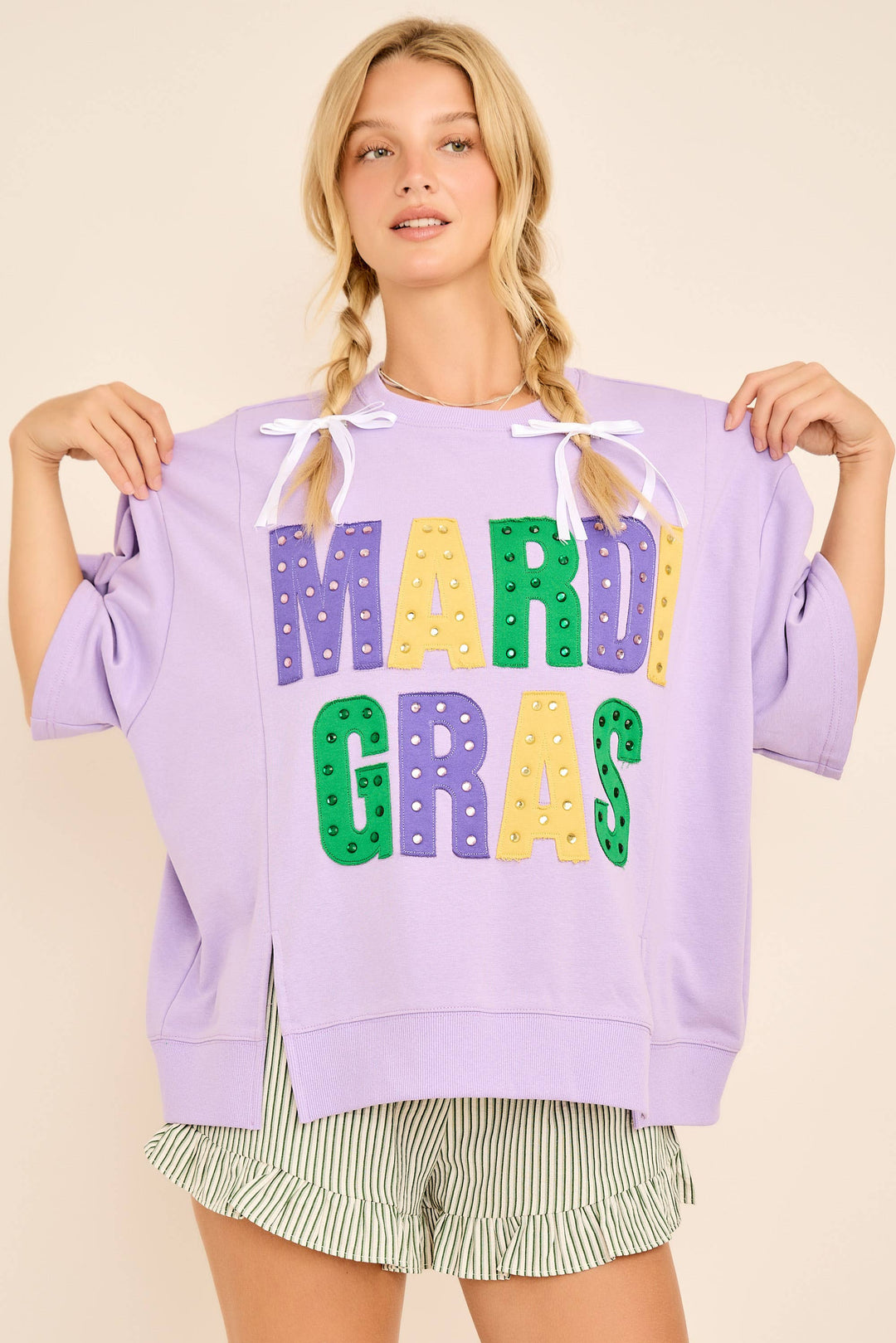 Woman holding a purple sweatshirt with colorful &