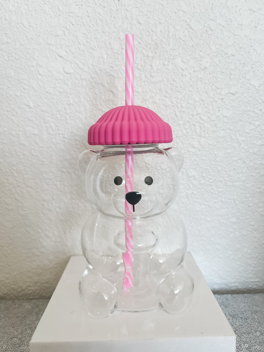 Glass bear shaped cup with a pink lid and straw