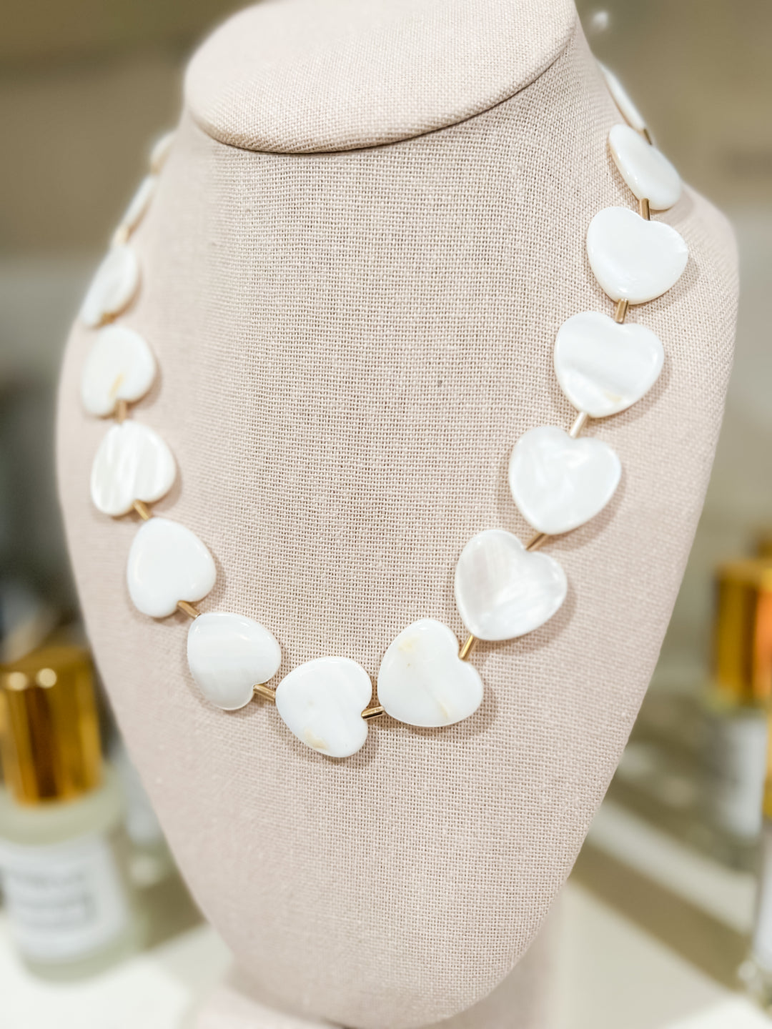 Necklace with white heart-shaped stones on a mannequin bust