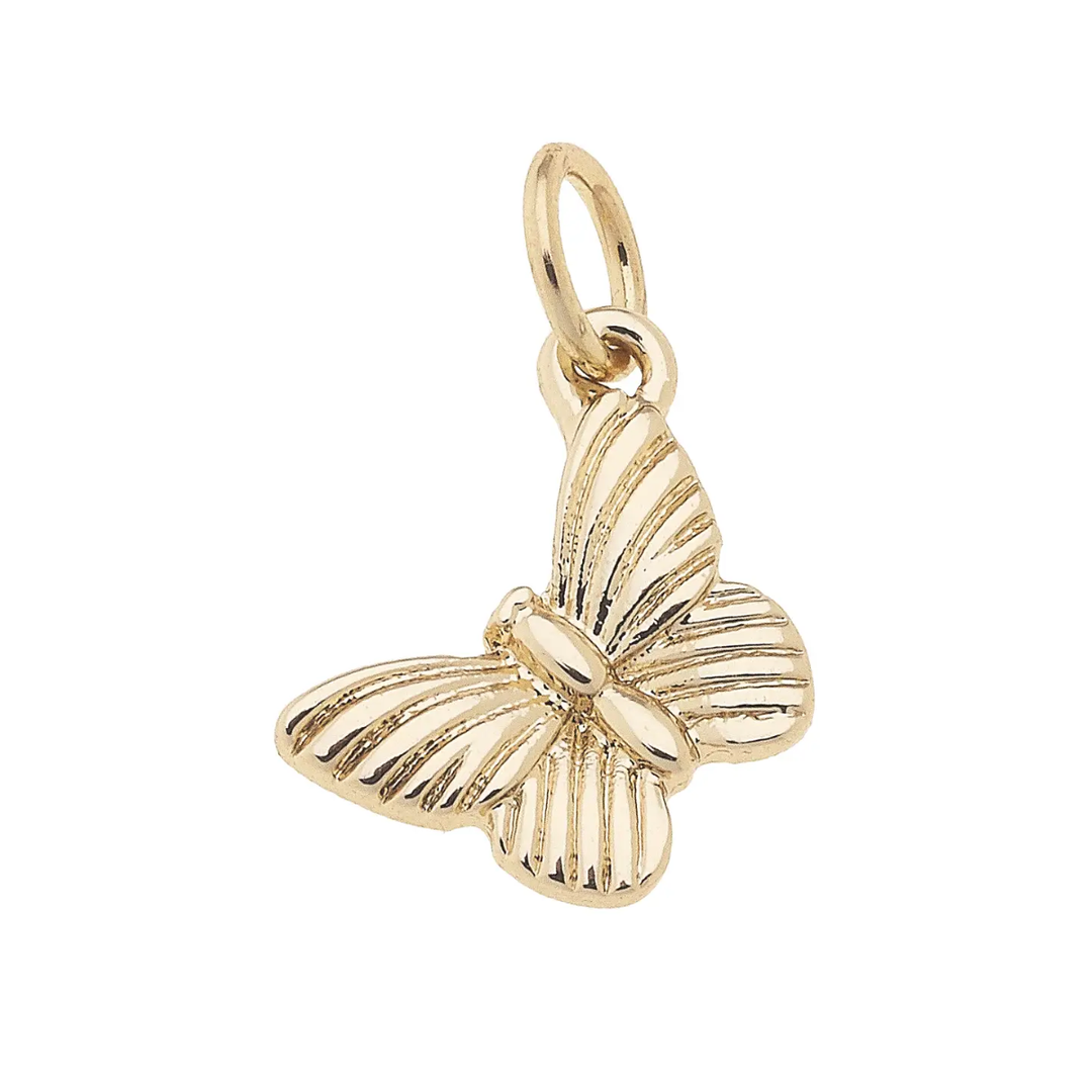 A shiny gold plated charm in the shape of a butterfly with intricate detailing.