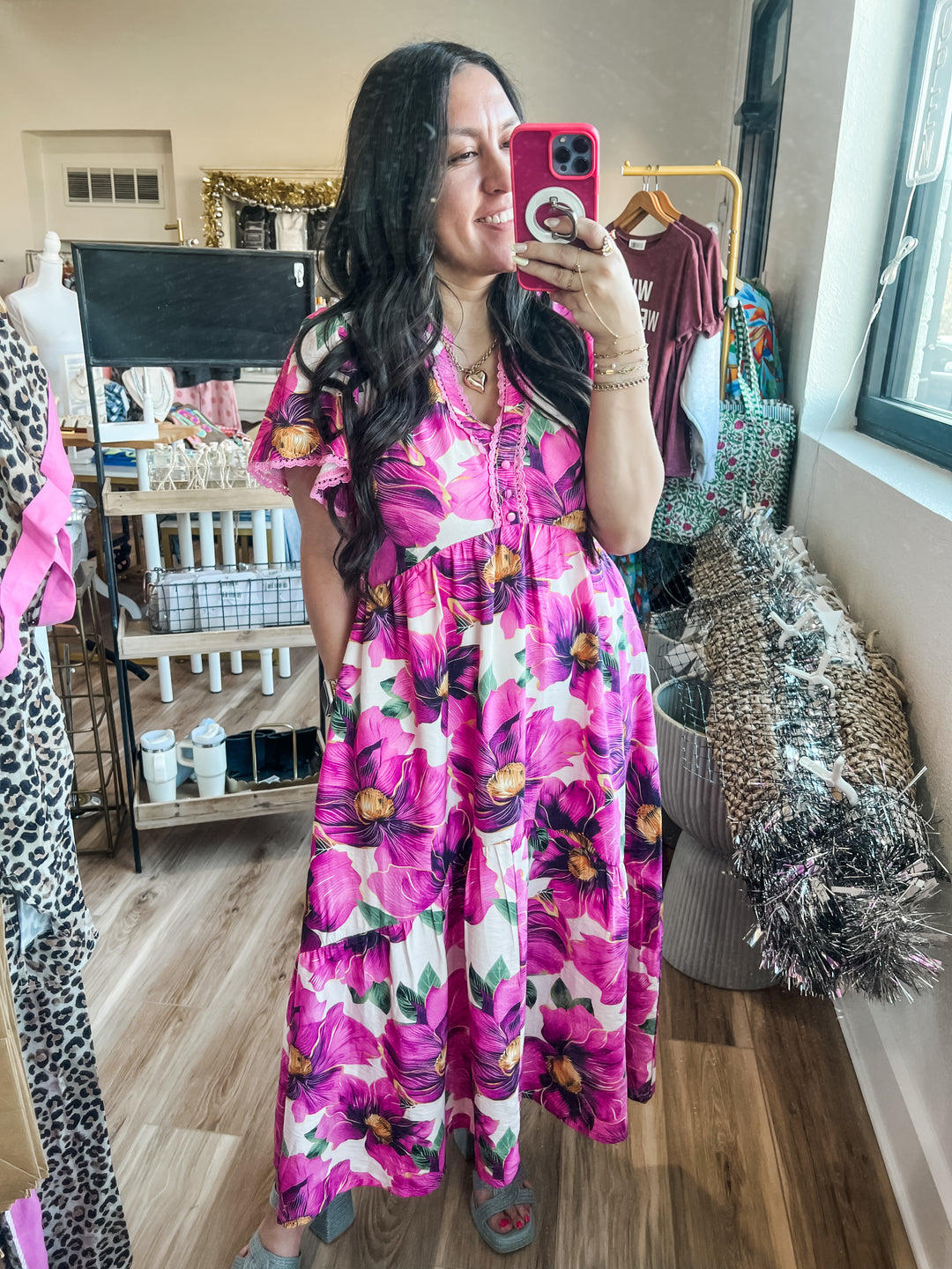 Woman taking a mirror selfie wearing a pink floral dress 