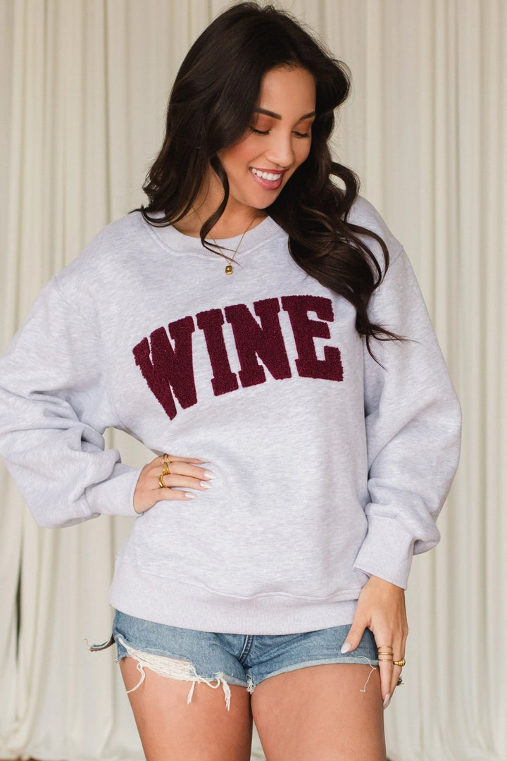 Woman wearing a gray sweatshirt with &