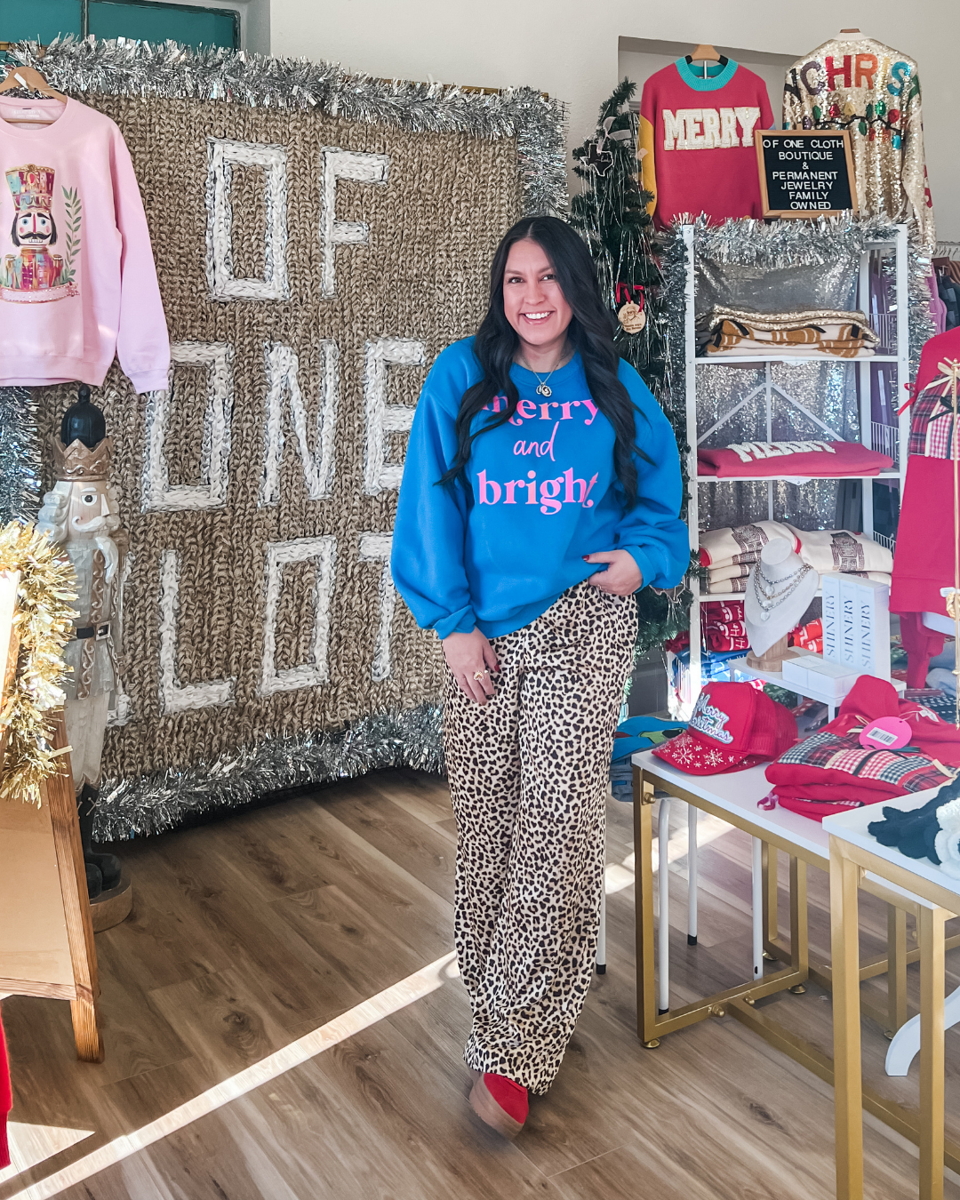 Woman in blue sweatshirt with "merry and birght' text