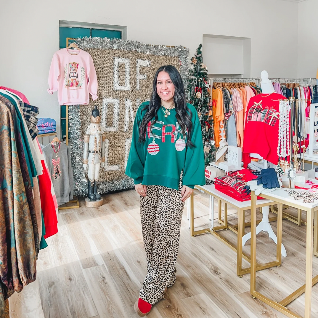 woman wearing grey sweater with 'MERRY" in appliqué 