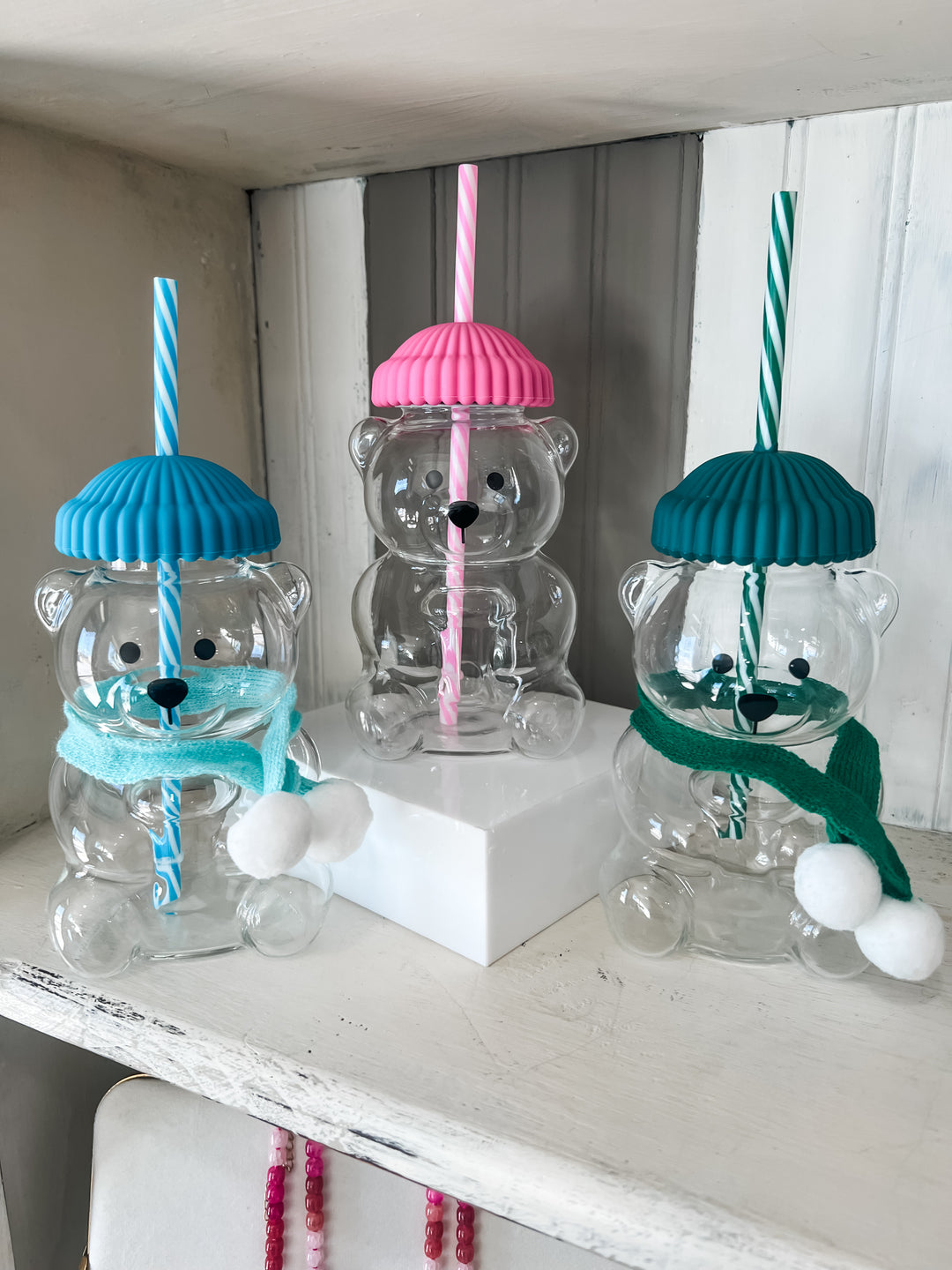 Bear-shaped glass jars with colorful lids and straws in pink, green and blue