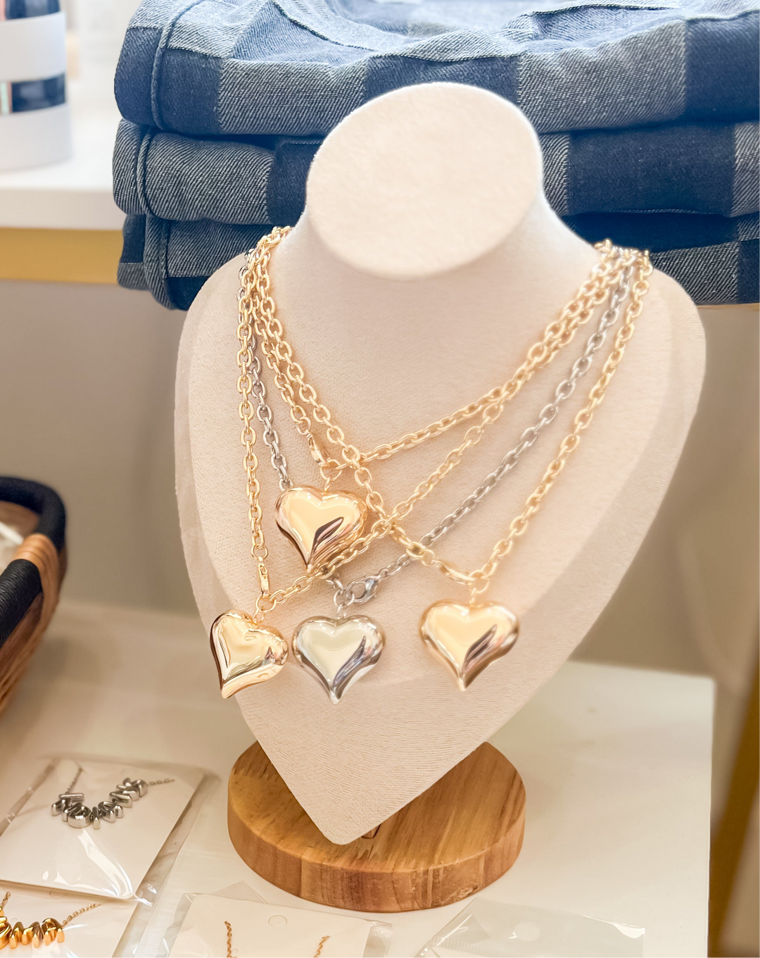 Necklace with heart pendants on a mannequin bust against a blurred background