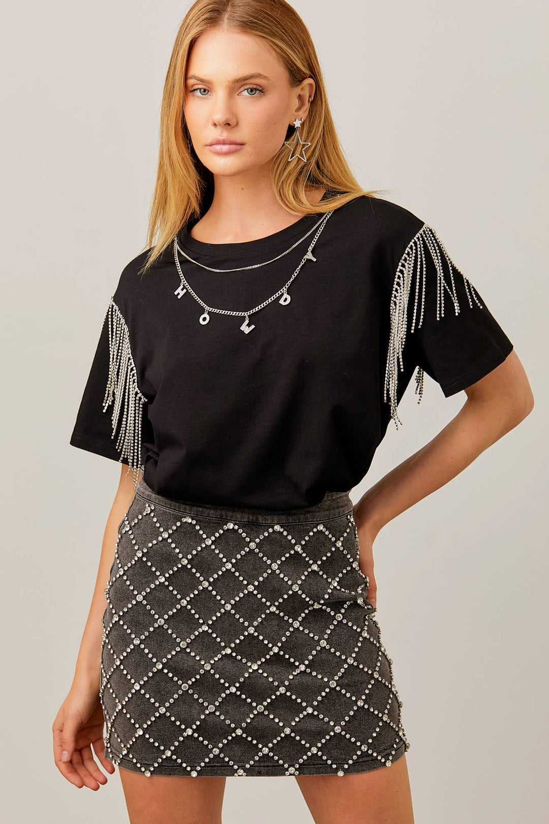 woman wearing a black denim skirt with rhinestones and a black shirt