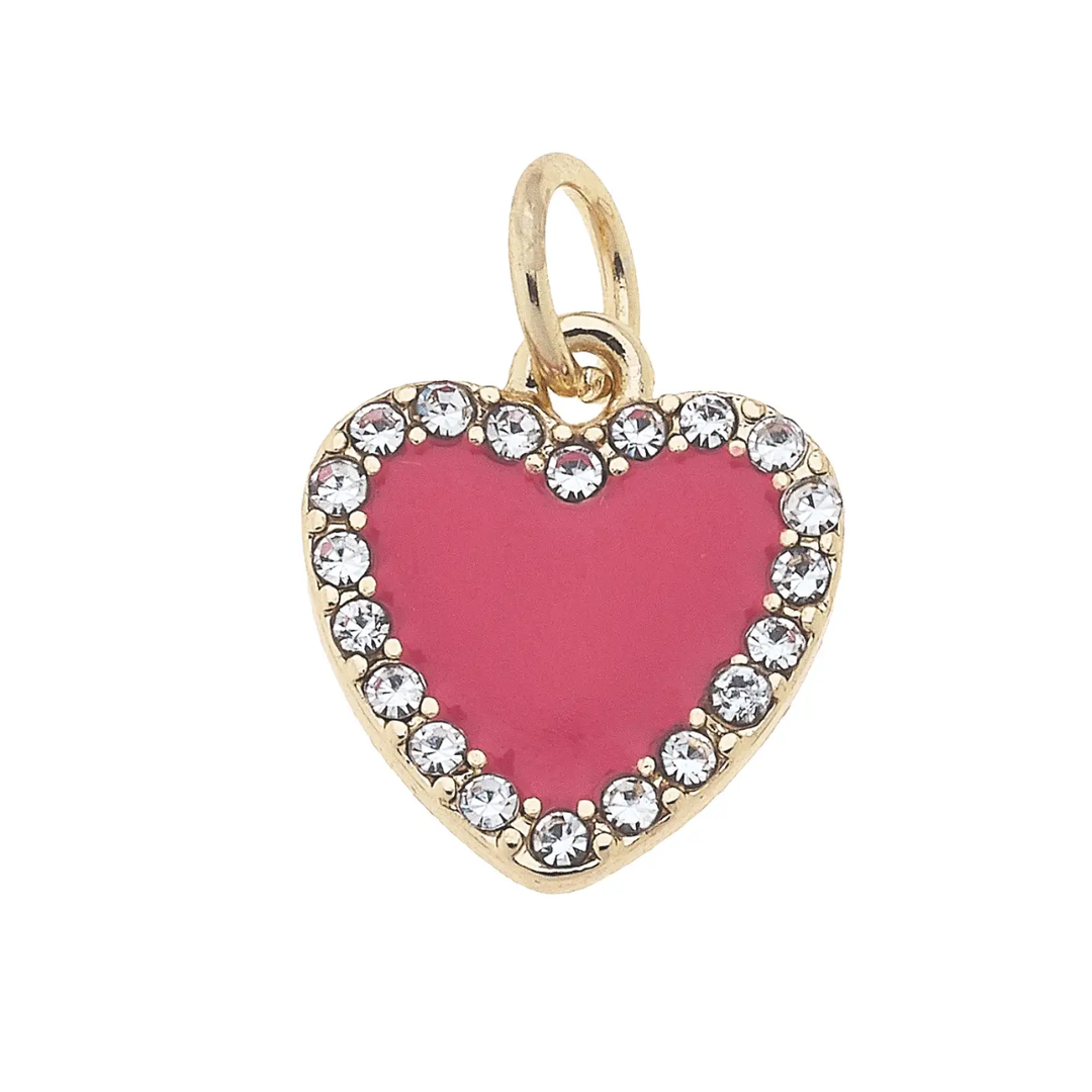 A fuchsia-colored enamel heart charm with gold plating and sparkling pave stones along the edges.