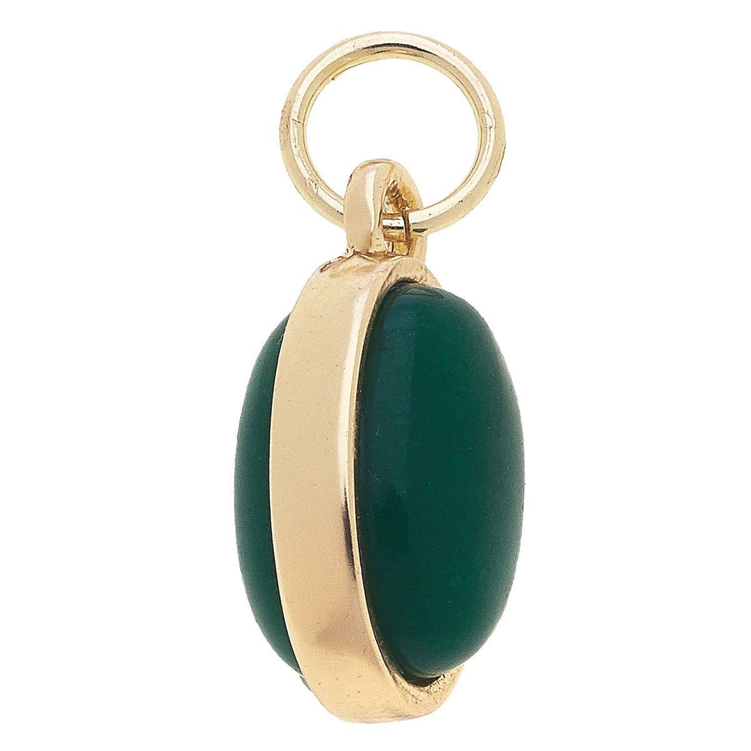 A gold-plated charm with a dyed green jade gemstone.