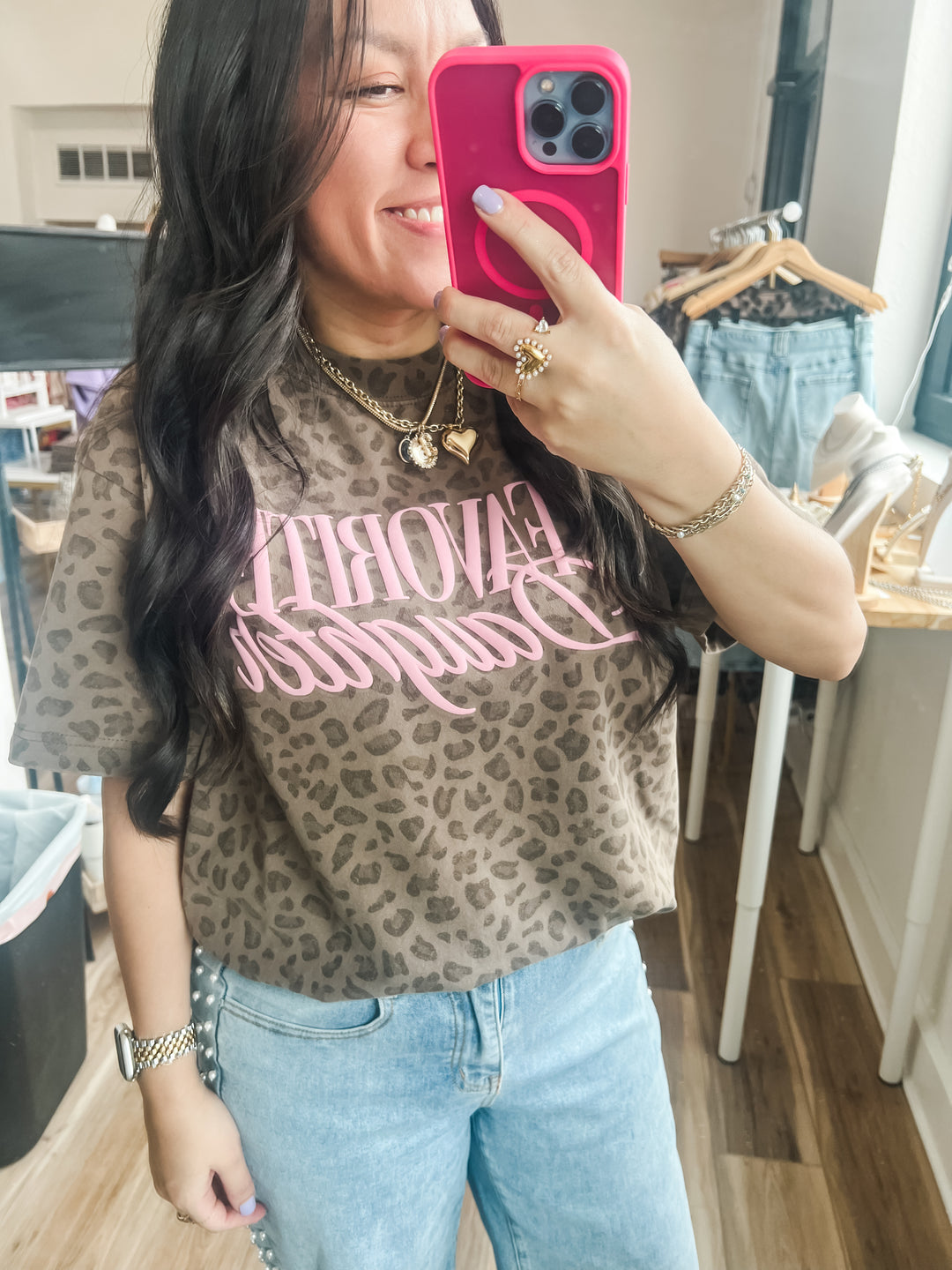 Woman wearing a leopard print shirt with pink text, "Favorite Daughter"