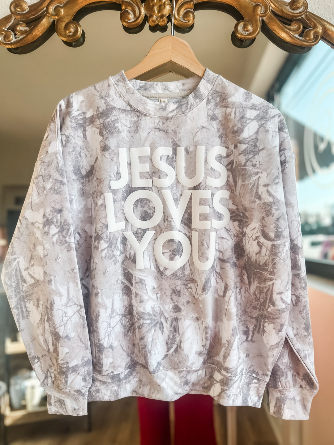 Cream camo sweatshirt with 'Jesus Loves You' text 