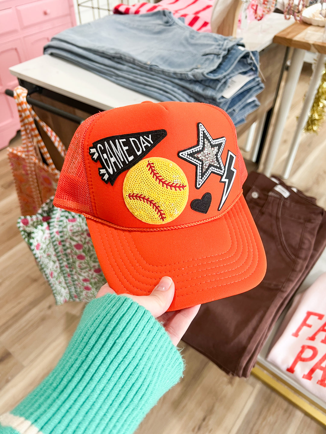 Orange trucker hat with softball themed patches