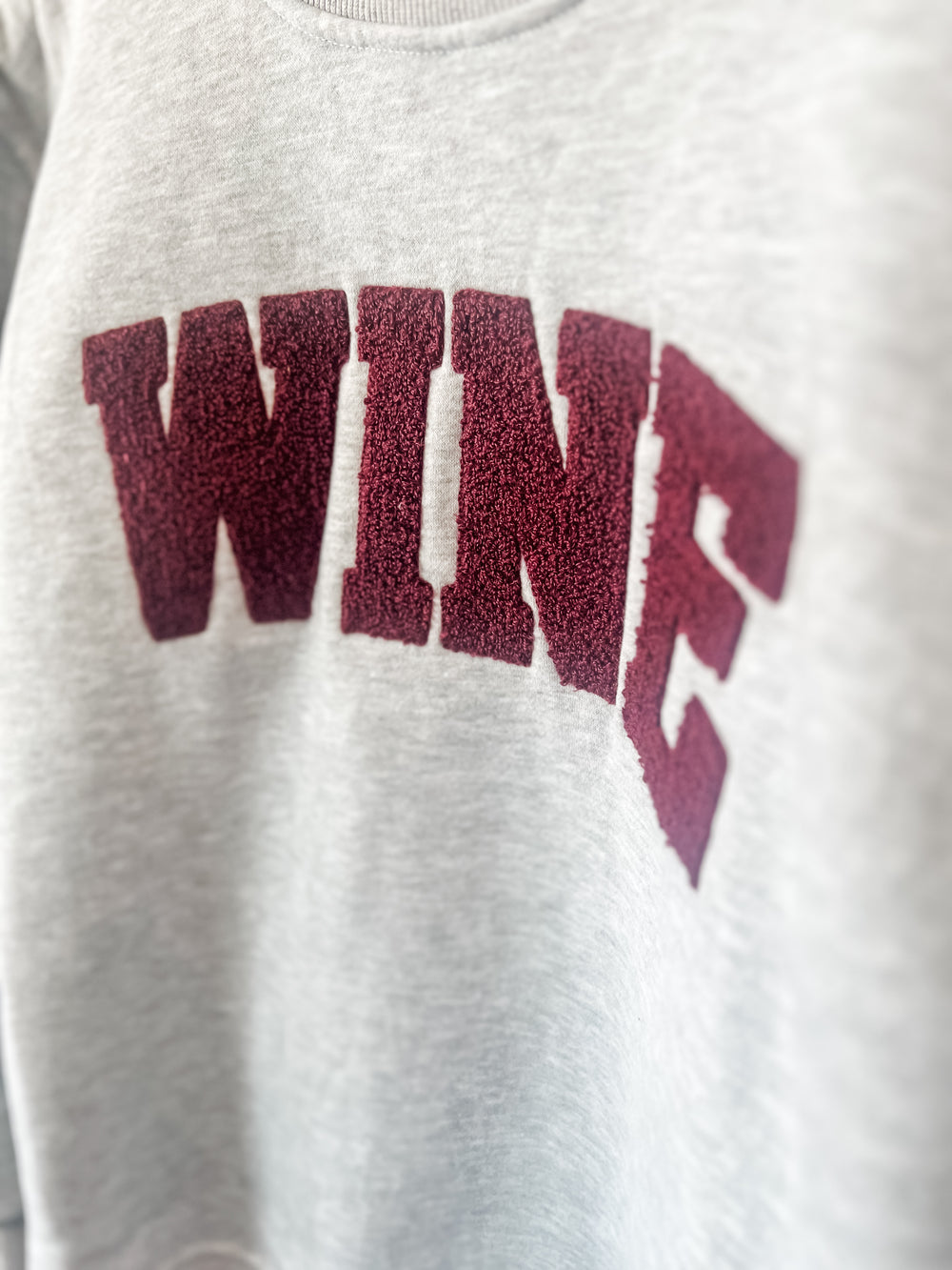 Gray sweatshirt with maroon 'WINE' text 