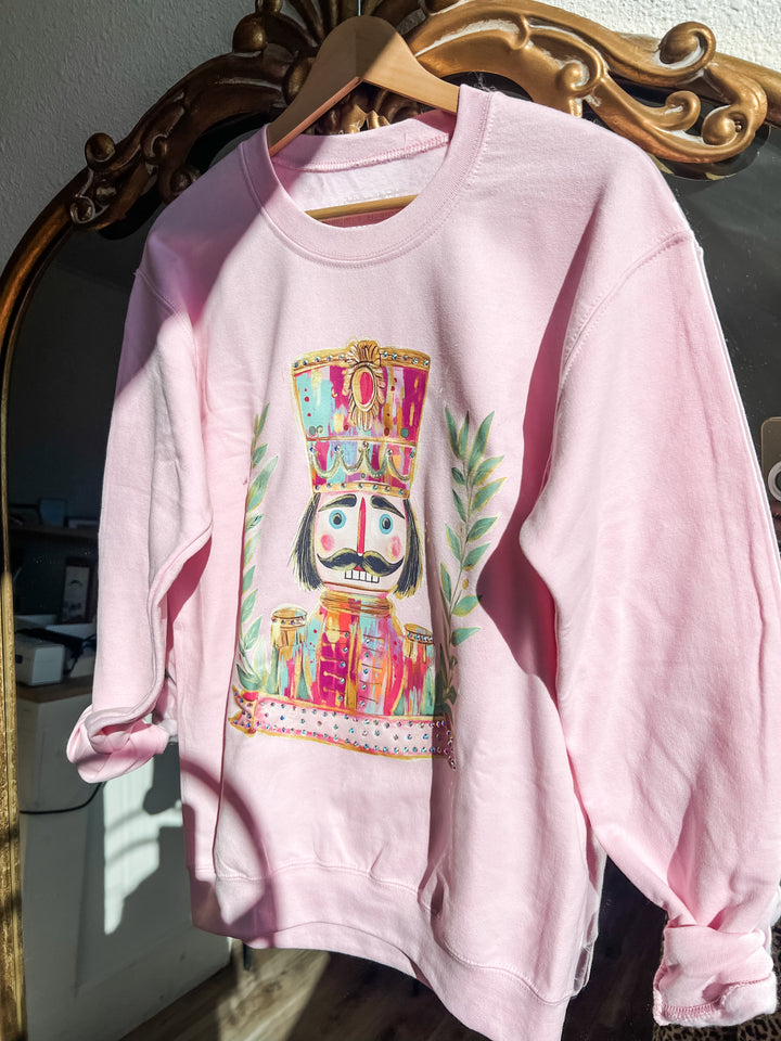 Pink sweatshirt with colorful nutcracker design 