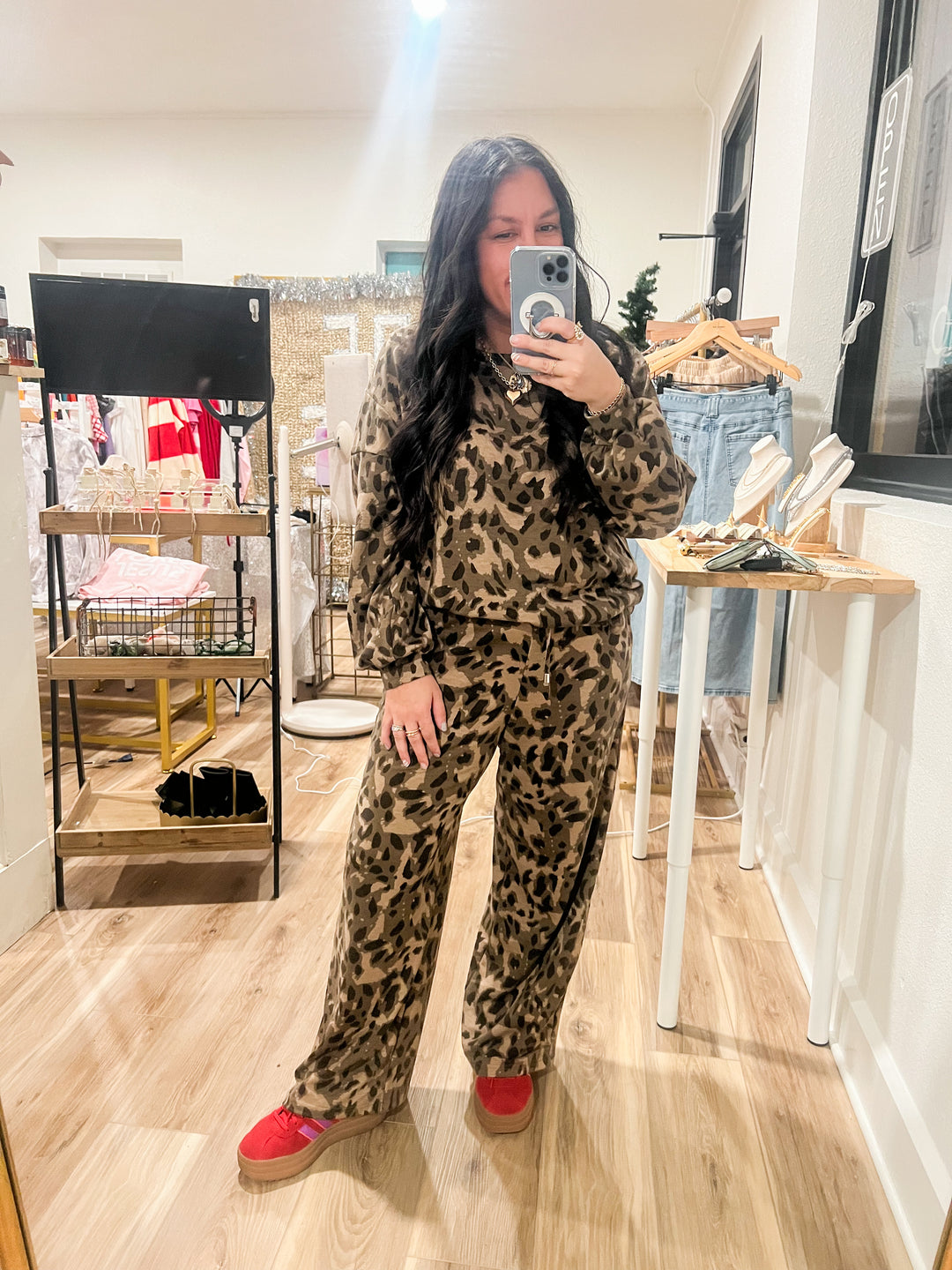woman wearing a leopard lounge set taking a selfie 