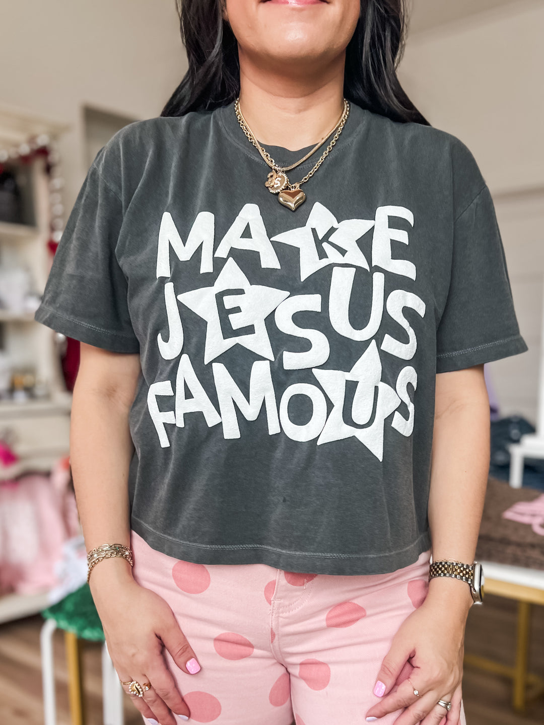 Woman wearing a dark gray t-shirt with 'Make Jesus Famous' text