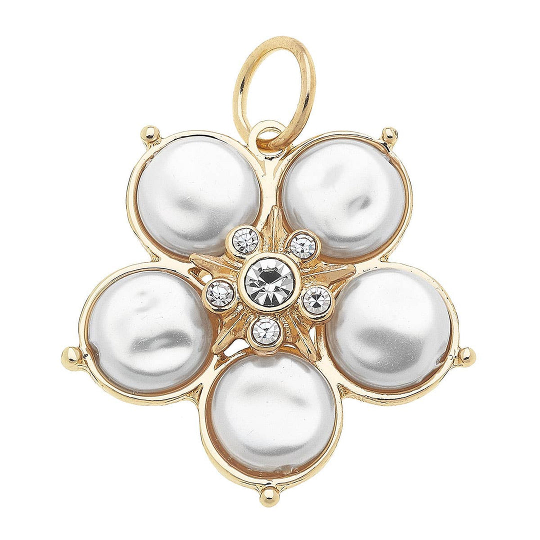 A gold-plated charm featuring a central ivory pearl with delicate petals and small clear stones.
