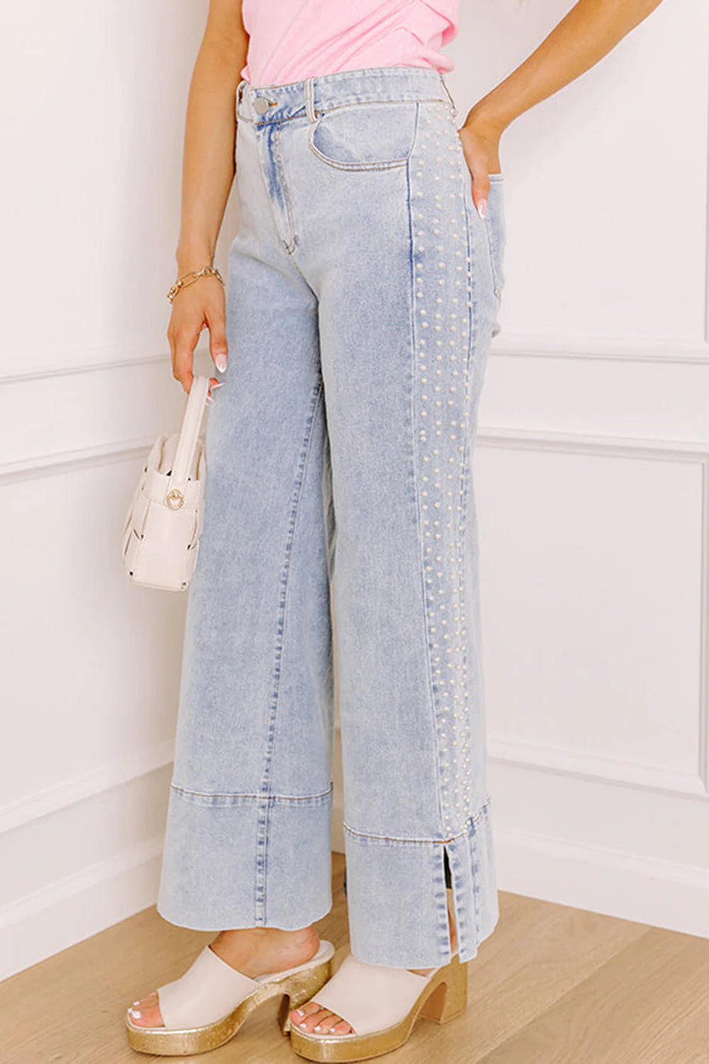 Person wearing light blue jeans with pearl embellishment 