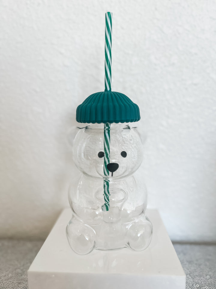 Clear glass bear with a green hat and straw 