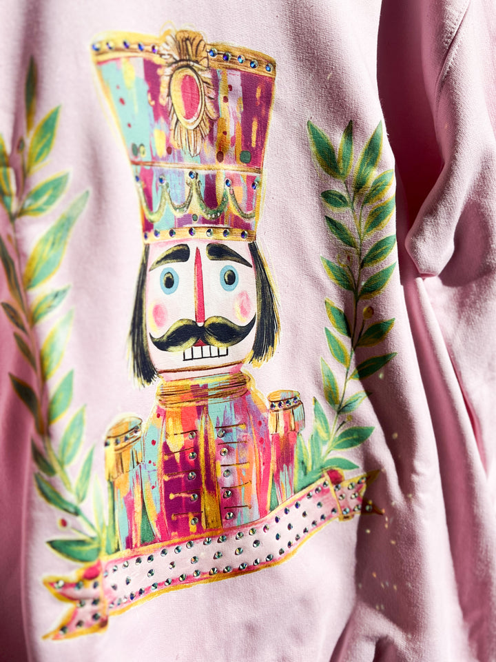 Colorful nutcracker design on a pink sweatshirt