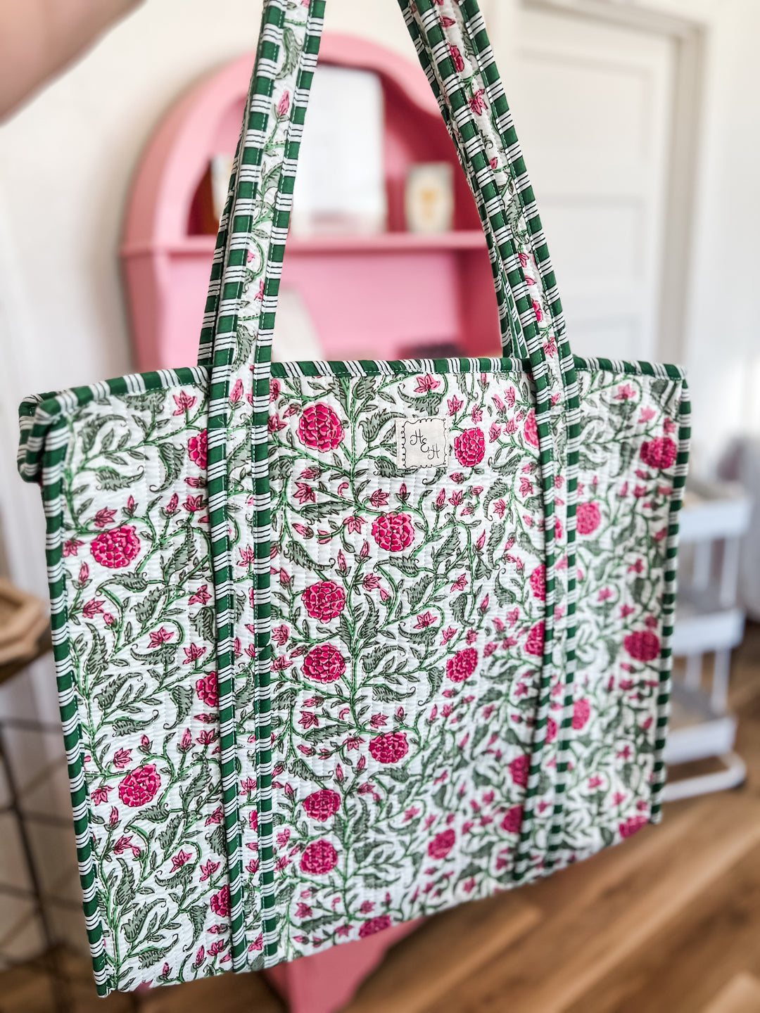Floral patterned quilt tote bag with pink flowers on a green and white background.