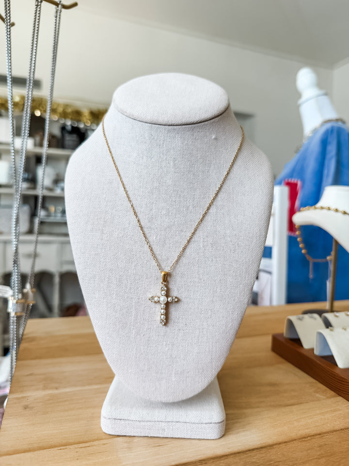 Pendant necklace with a cross and small clear stone and pearl details 