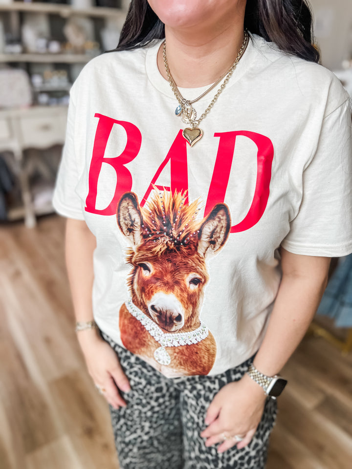 Person wearing a white t-shirt with a donkey graphic and &