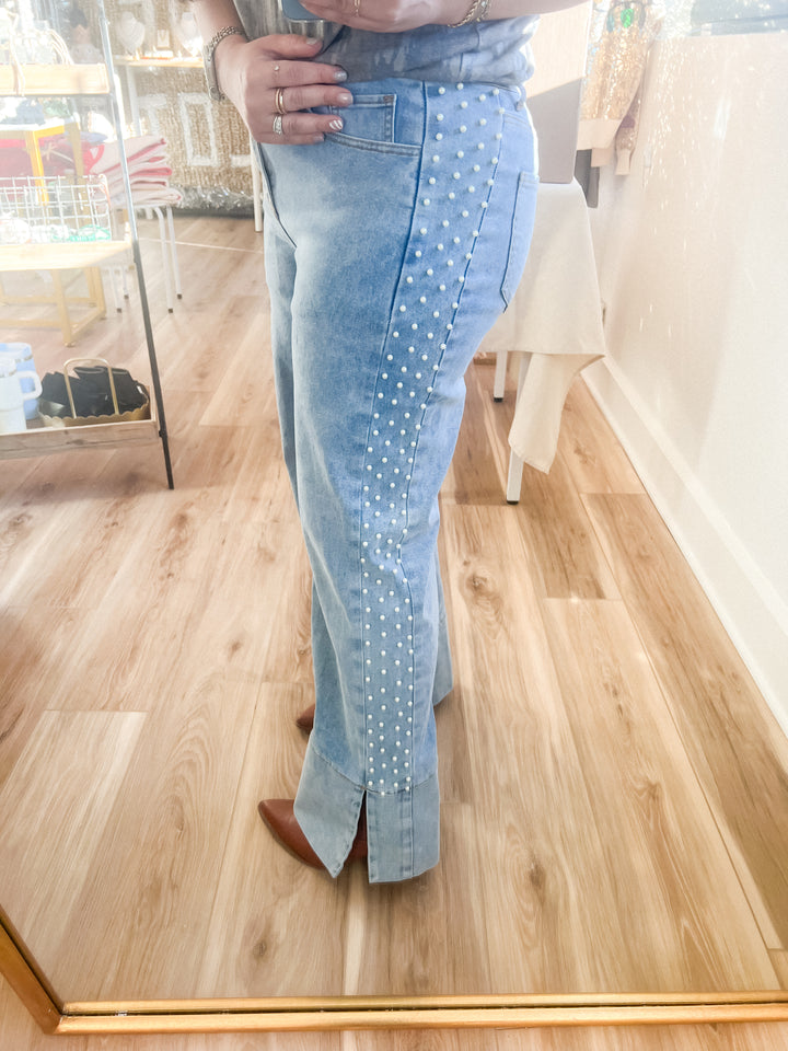 Woman wearing light blue jeans with a pearl pattern on the side