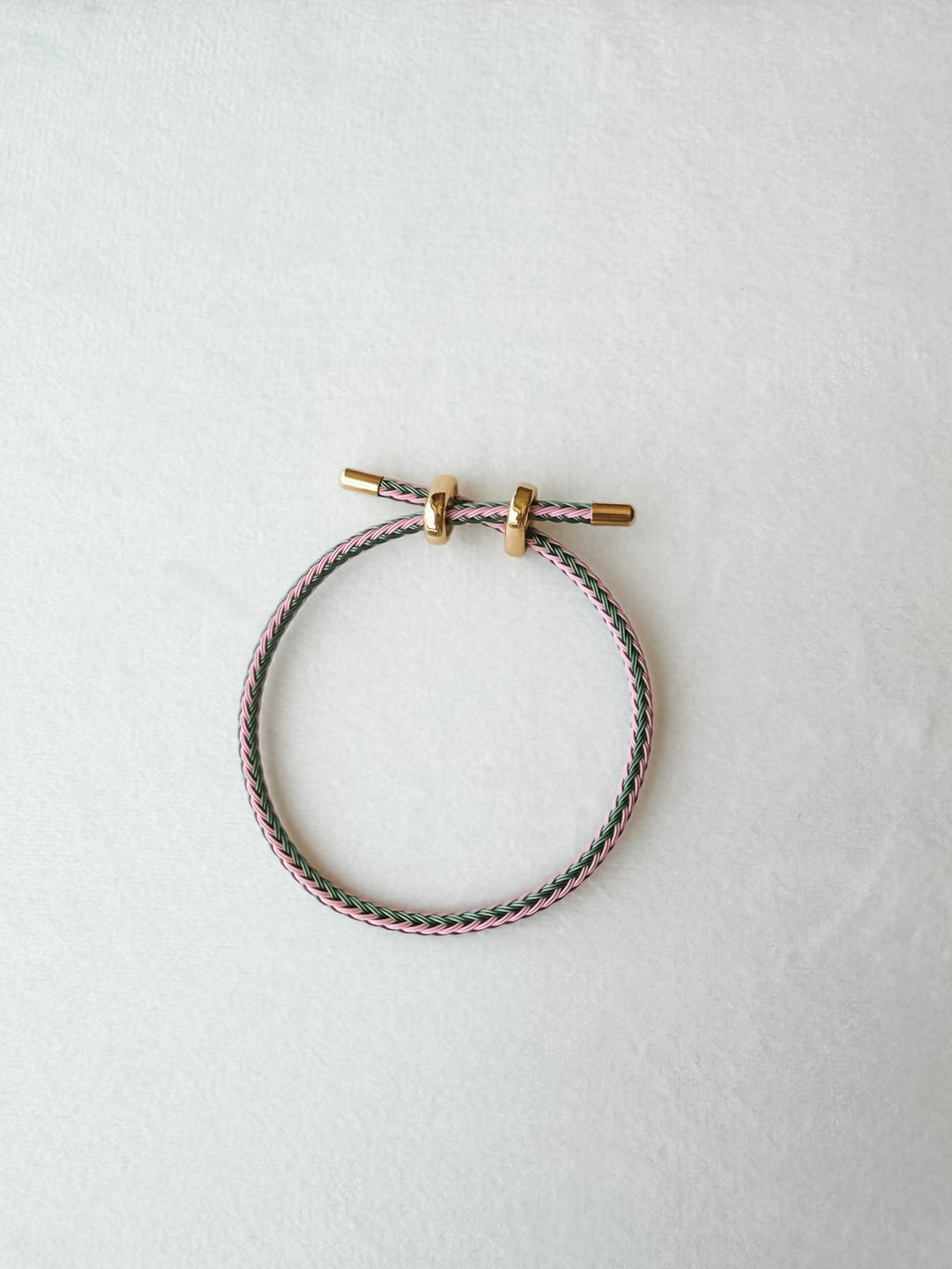 Green and pink adjustable paracord bracelet with gold accents