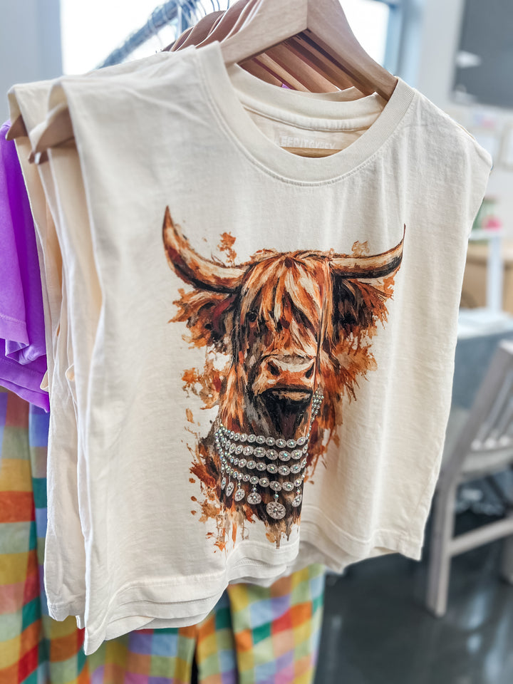 Cream t-shirt with a highland cow design on a hanger