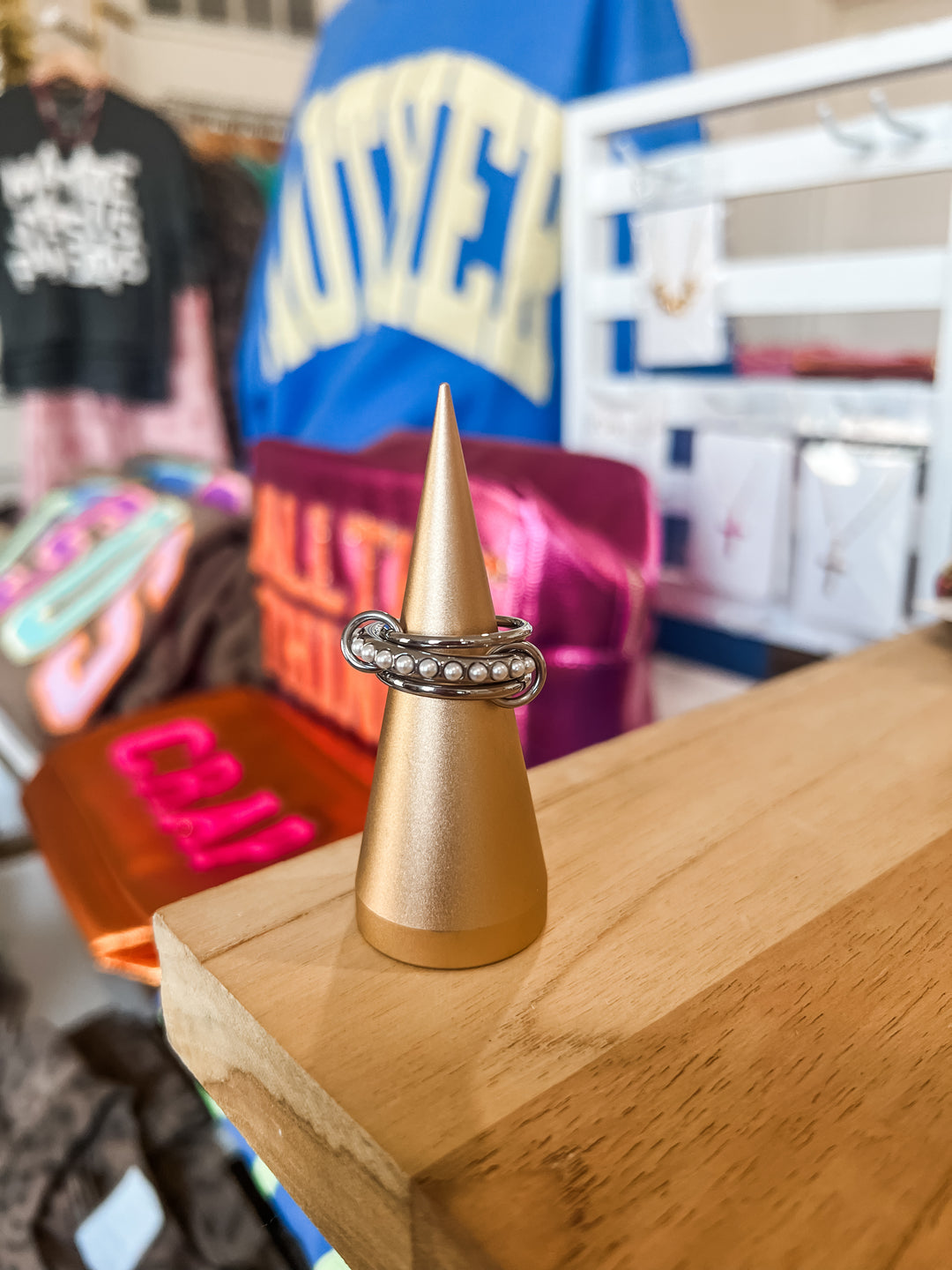 Three silver stainless steel stacked rings joined by jump-rings. Center ring with pearl embellishments