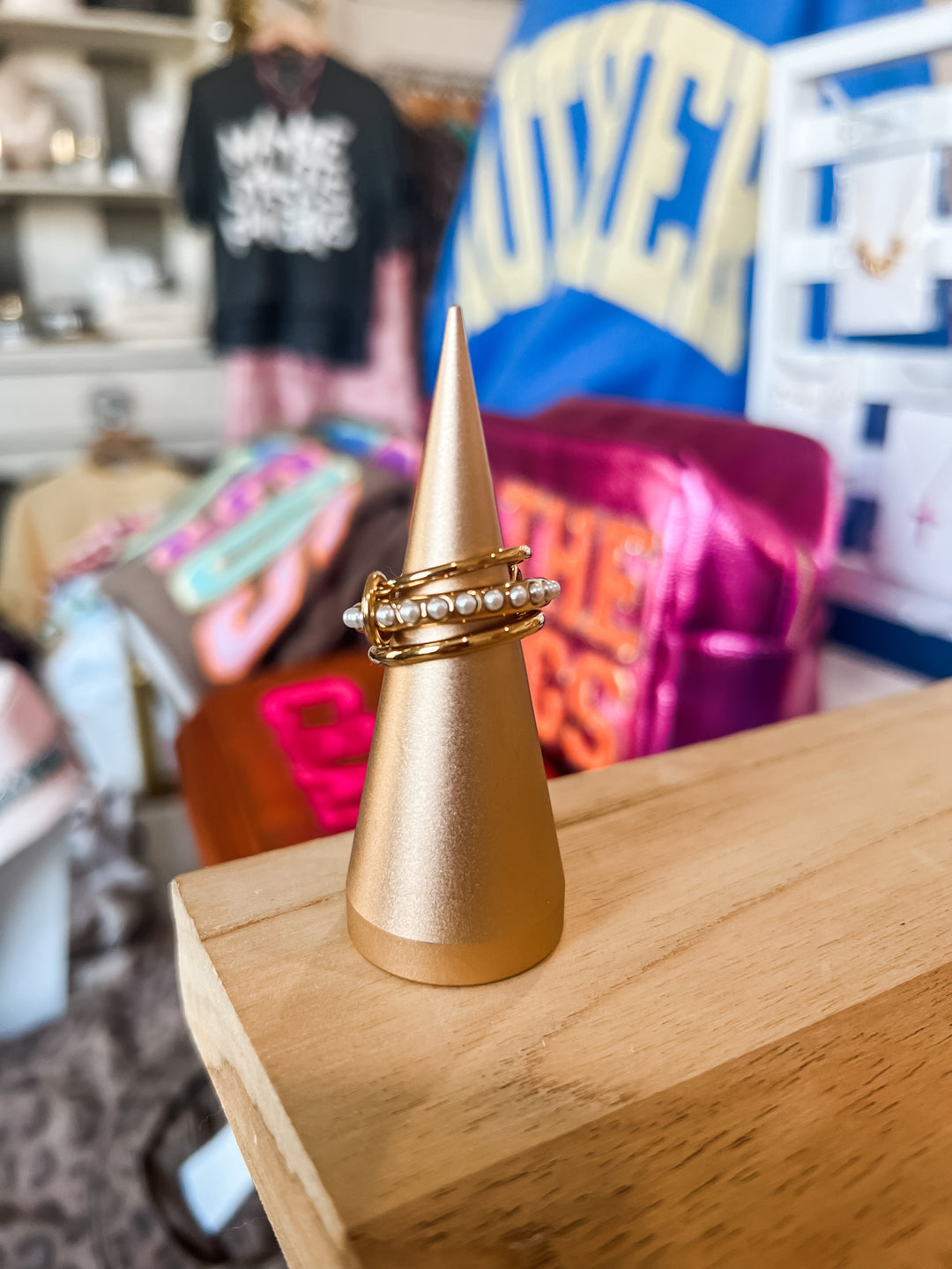 Three gold stainless steel stacked rings joined by jump-rings. Center ring with pearl embellishments