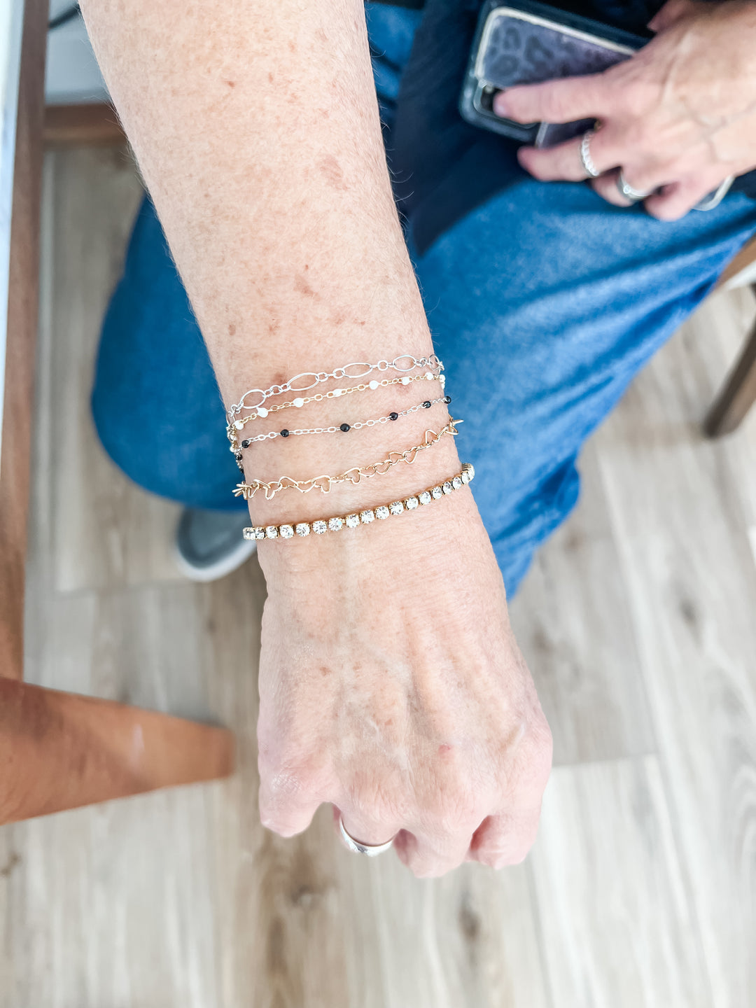 Woman wearing multiple permanent jewelry bracelets North Texas