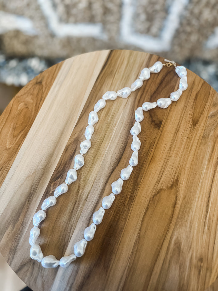 Pearl necklace on a wooden surface