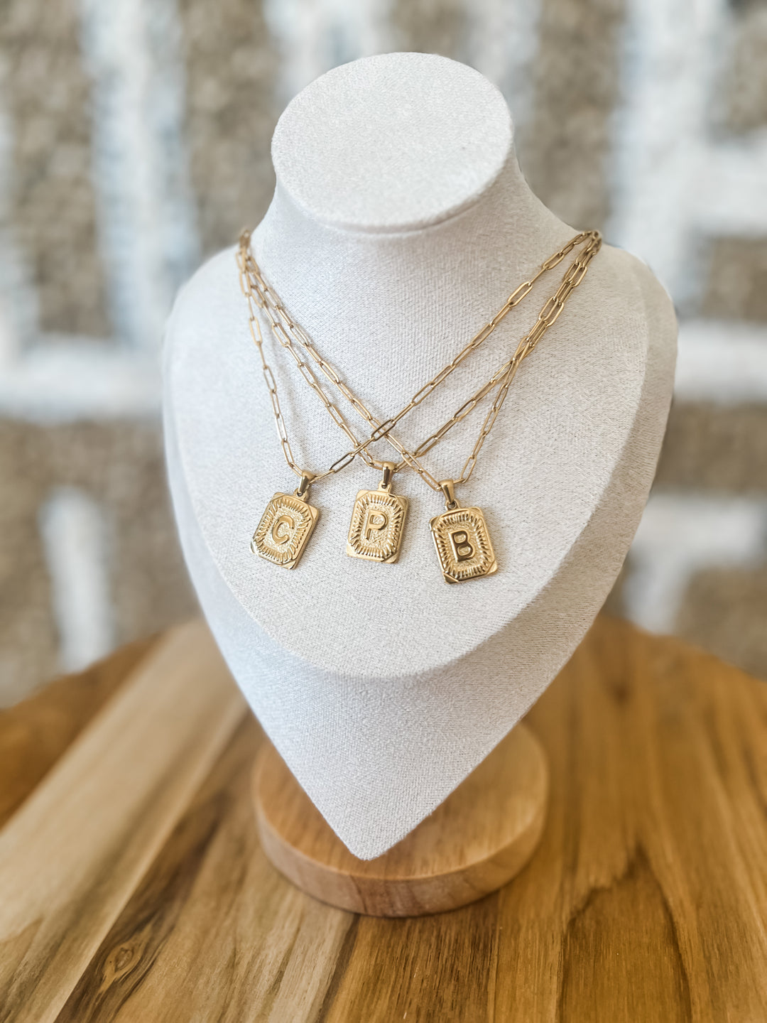 Three gold necklaces with letter pendants 