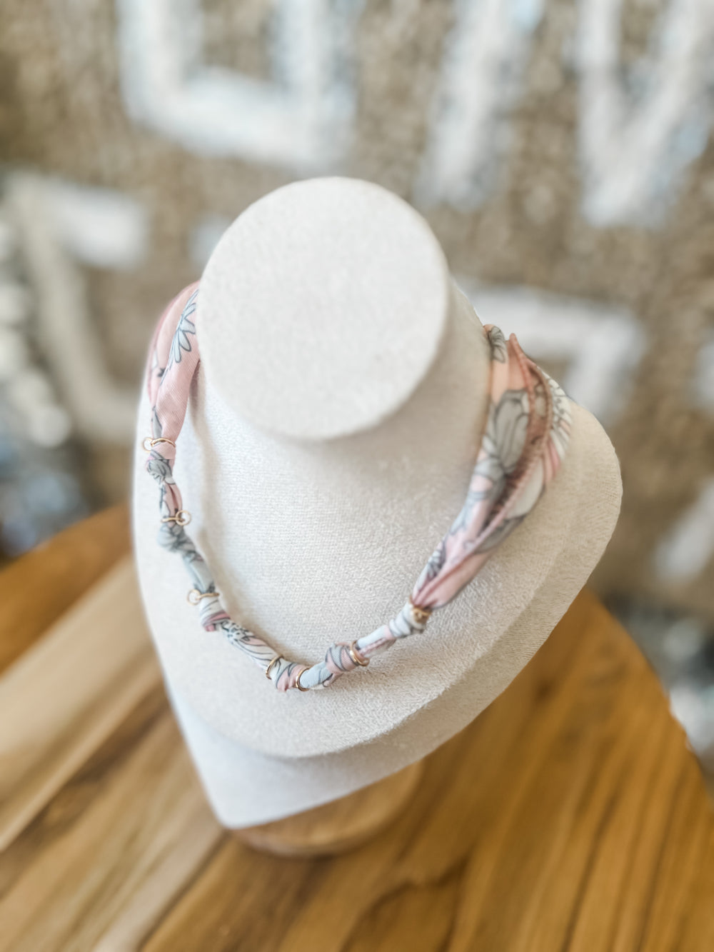 Necklace on a white mannequin bust with a blurred background