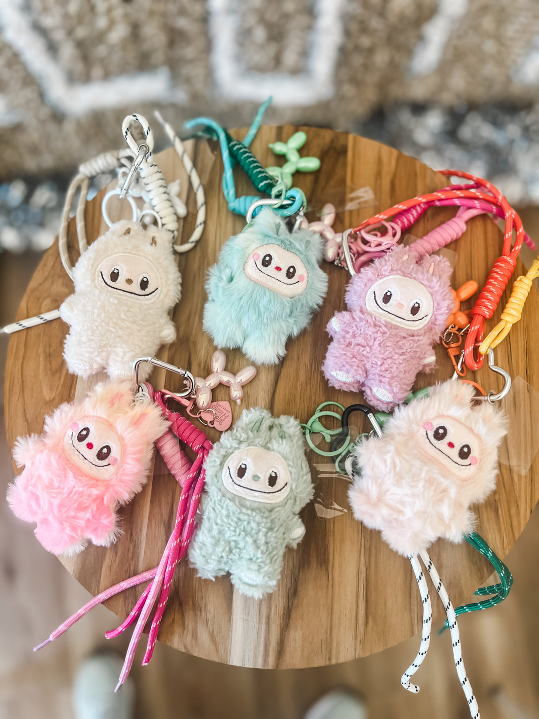 Set of colorful plush keychains on a wooden board