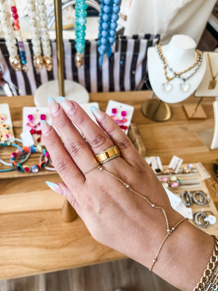 Gold crystal accent waterproof ring styled stacked with gold bands on model&