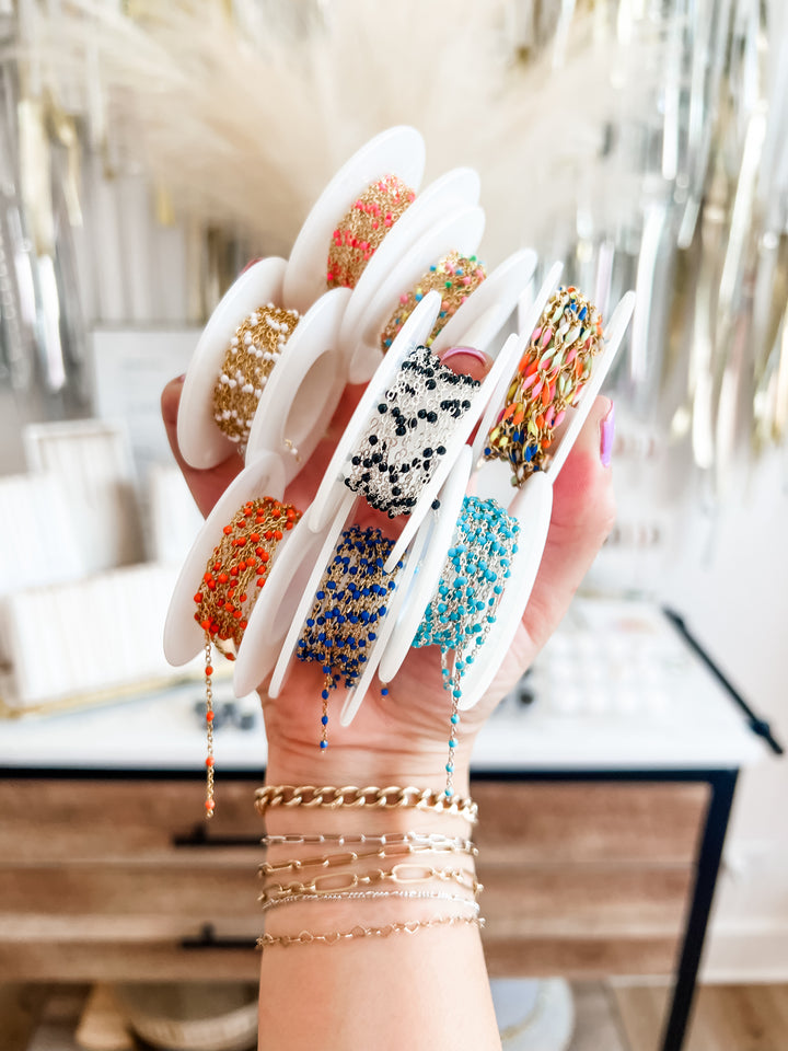 Hand holding permanent jewelry colorful chains