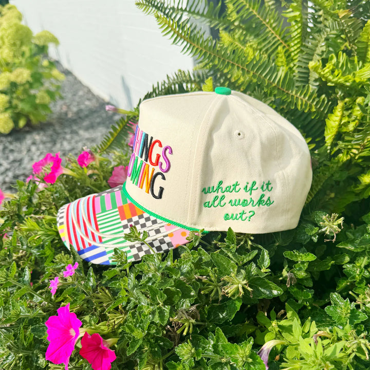 beige trucker hat with "WHAT IF IT ALL WORKS OUT?" text