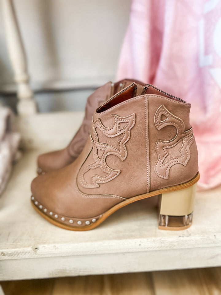 Brown cowboy boots with decorative patterns and clear block hill