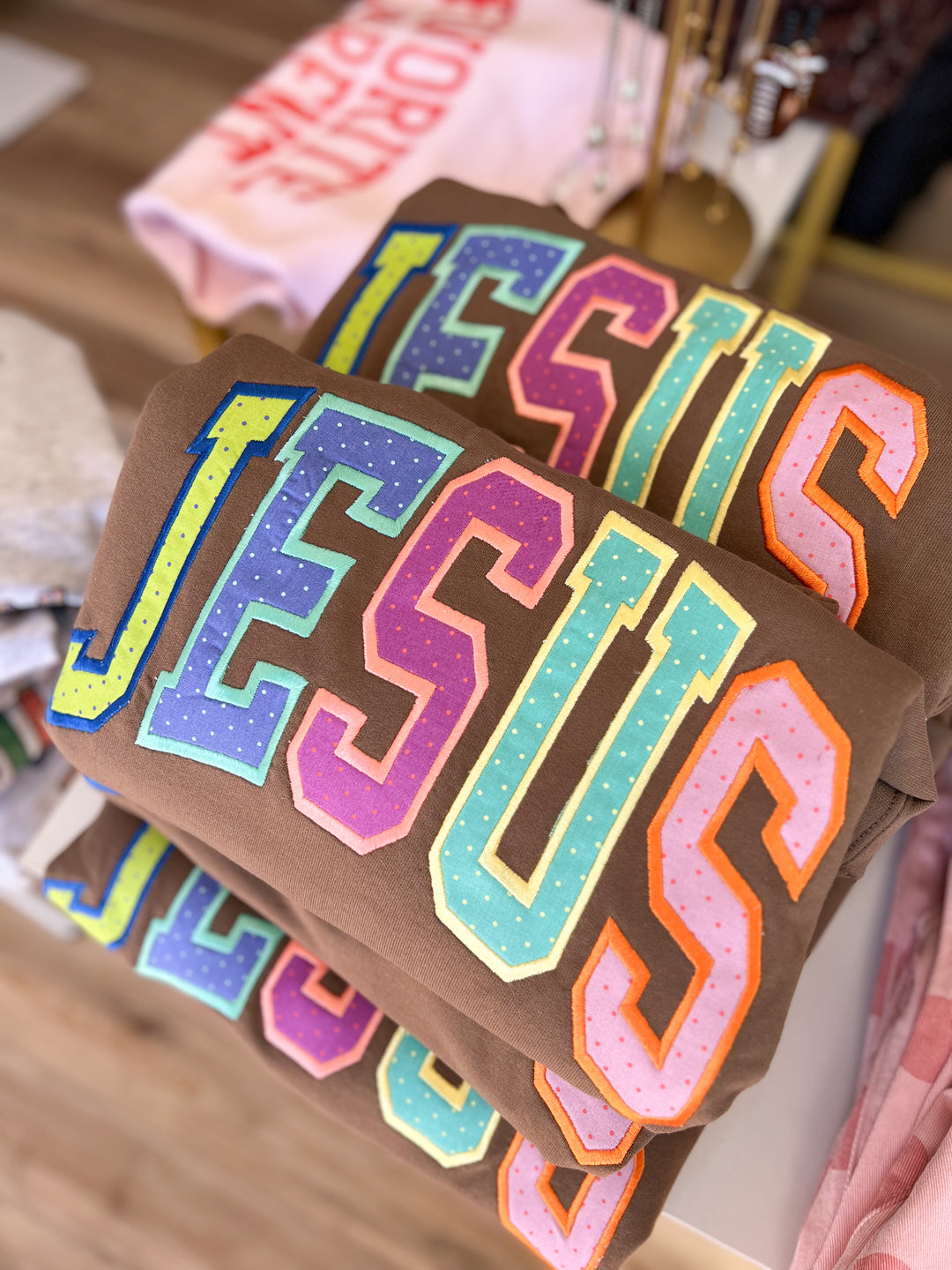 Colorful 'JESUS' text on brown fabric