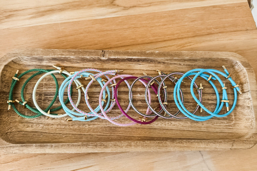 a group of colorful adjustable paracord bracelet with gold accents