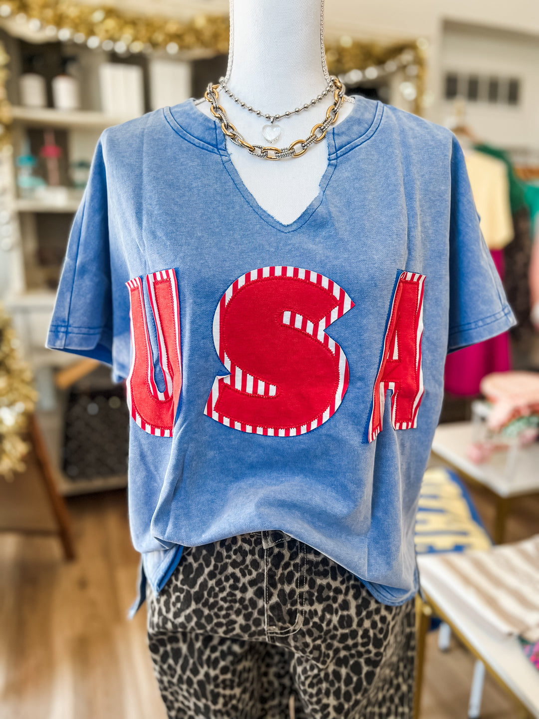 Mannequin wearing a blue t-shirt with a red 'USA' design in a store setting