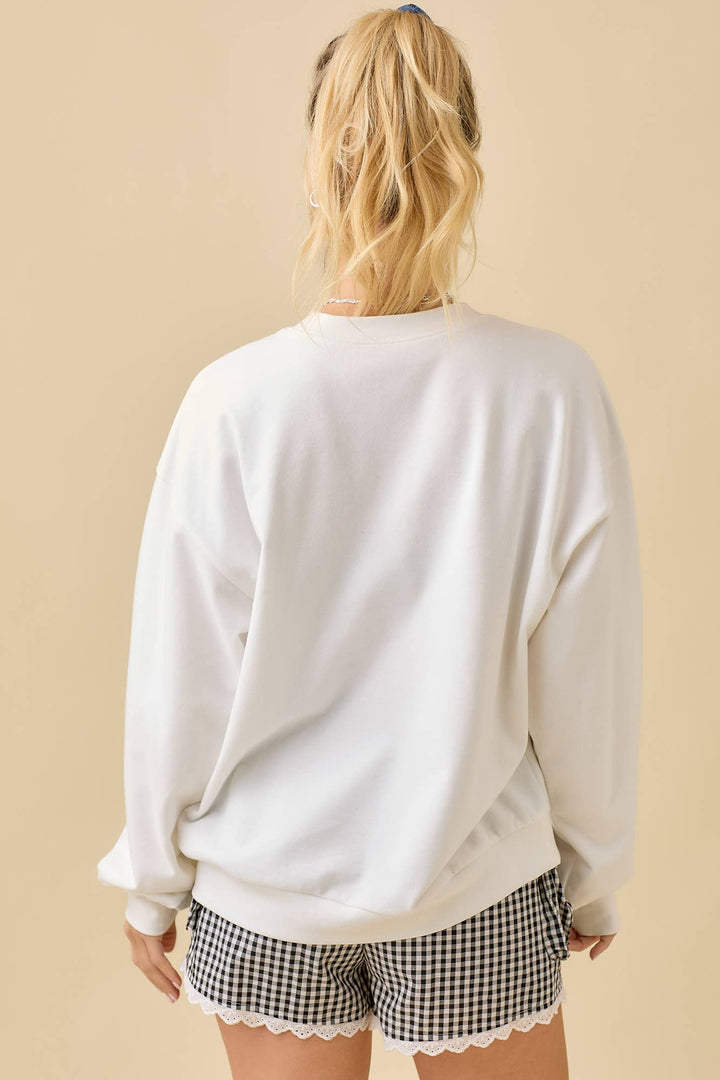 Person wearing a white sweatshirt and checkered shorts on a beige background