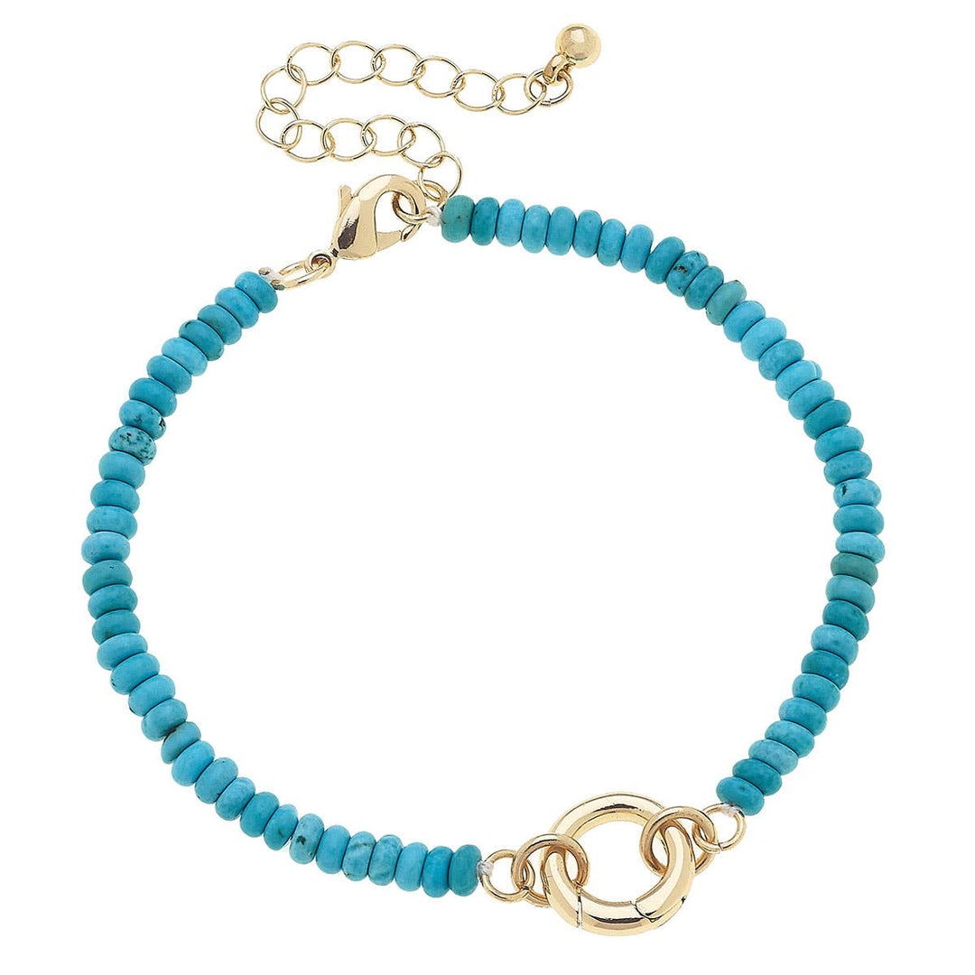 A turquoise beaded charm bracelet with gold plating and a lobster clasp closure.