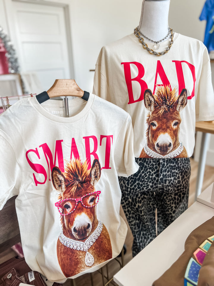 Two t-shirts with donkey graphics and text on a mannequin and hanger.