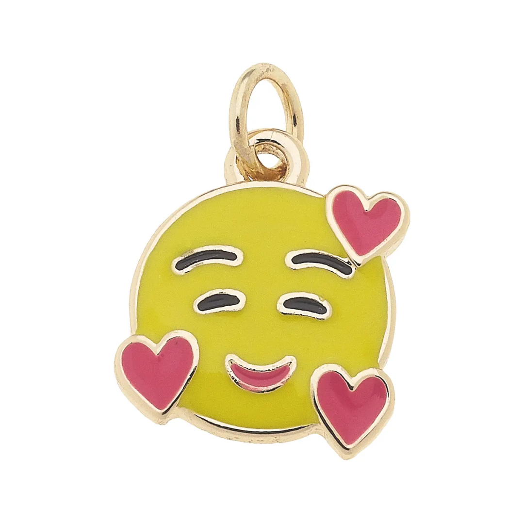 Emoticon charm with a yellow face, pink hearts, and winking eyes on a white background