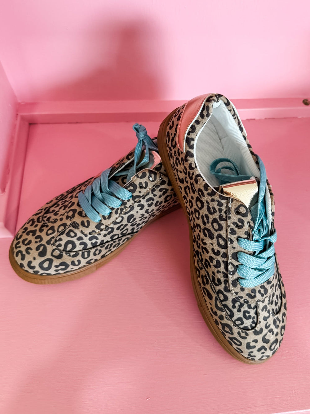 beige and black leopard shoes with teal laces 