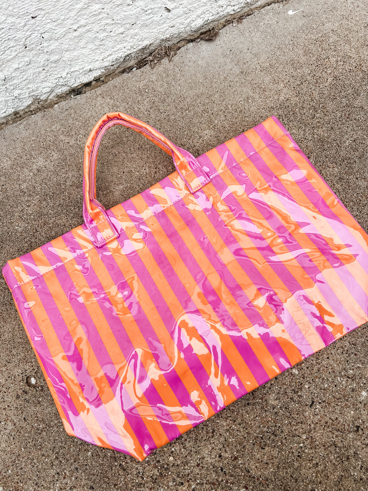 Striped pink and orange bag on a concrete surface